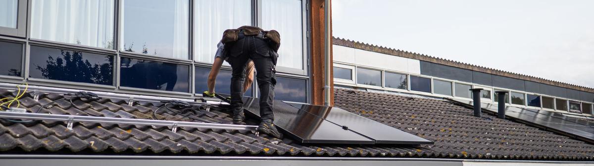 Installateur posant des panneaux sur le toit d'une maison